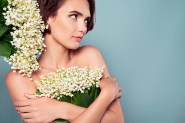 Yumuşak rüya gibi kadın çiçekleri tutarken doğal parfüm reklamları yaparken çekilmiş bir fotoğraf..