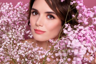 Stüdyoda gülümseyen hoş bir bayanın portresi yumuşak yumuşak tenin tadını çıkarıyor pembe arka plan.