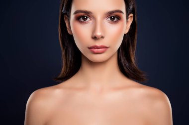 Doğal güzelliği vurgulayan zarif bir portre, kusursuz bir cilt, ve çekici koyu bir arka plana karşı esmer bir kadının ince makyajı.