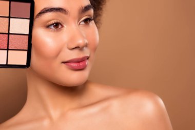 Hassas, güzel bir bayanın bej renkli arka planda izole edilmiş profesyonel maquillage fotoğrafı..