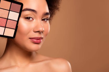 Hoş, nazik, çarpıcı bayanın fotoğrafı. Pasta renginde. Bej arka planda izole edilmiş boş bir alan..