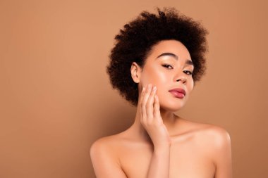 Oldukça nazik bir bayanın fotoğrafı sağlıklı cilt soyma, bej rengi arka planda izole edilmiş şımartma işleminden zevk alır..