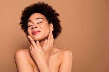 Şefkatli, nazik bayanın fotoğrafı bej renkli arka planda izole edilmiş temiz ve saf derinin tadını çıkar..