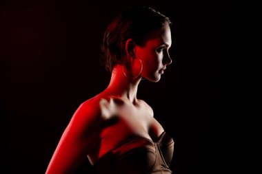 Göz kamaştırıcı, genç, seksi kadın VIP gece kulübü neon kırmızı ışık giyinmiş siyah renkli arka plan modasına uygun elbisenin fotoğrafı..