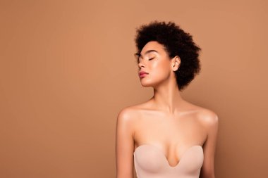 Sevimli, tapılası, hayalperest kadının resmi. Kapalı gözler. Bej renkli arka planda izole edilmiş vücut bakımı..