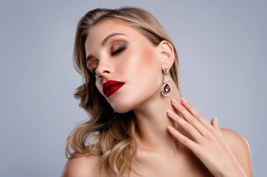 Değerli taş küpeler takan muhteşem bayan Sevgililer Günü hediyesi. Kapalı gözlerle dokunmanın tadını çıkar..