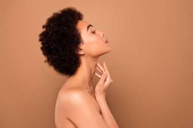 Profil kenarındaki sevimli nazik bayanın fotoğrafı bej rengi arka planda izole edilmiş anti-yaş kremi sürün..