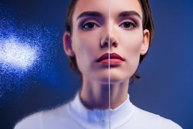 Büyüleyici bir bölünme etkisi olan beyaz elbiseli genç bir kadının çarpıcı görüntüsü modern güzelliği, modayı ve mavi ışıkta büyüleyici bir kompozisyonu vurguluyor..