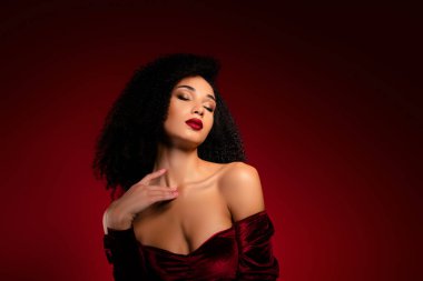 Çekici, lüks bir kadının fotoğrafı. Gözlerin kapalı, göğsüne dokun. Şefkat elbisesi giy..