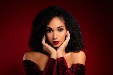 Güzel kıvırcık saçlı kadın kameraya bakıyor kadife elbise giymiş parlak makyajlı..