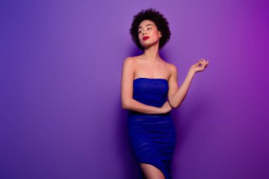 Mor gradyan arka planda zengin, şık, şık bir bayanın şık bir gece kulübü pozu..