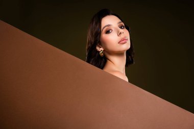 Zarafet ve cazibeyle poz veren şık ve modaya uygun bir genç kadın. Karanlık ve şık bir arka planda güzellik, moda ve cazibenin mükemmel bir temsili. Moda ve yaşam tarzı kavramları için ideal..