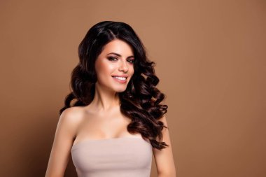 Tarz bej arka plan, somut güzellik, zarafet ve entelektüellik üzerine kurulu dalgalı kahverengi saçları ve profesyonel makyajıyla doğal cazibesini sergileyen zarif bir genç kadın..