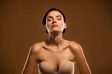 Sakin bir ortamda doğal güzellik ve çekicilik sergileyen zarif genç bir kadın. Cilt bakımı, vücut bakımı ve kadınsı zarafeti ön plana çıkarmak..