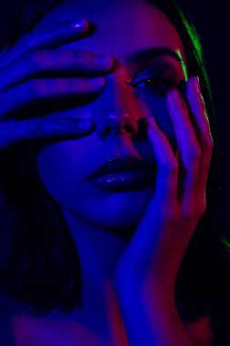 Göz alıcı bir kadın portresi. Neon ışıklı. Canlı renkler güzellik, moda ve yaratıcılığı vurgular, modern sanat ve fotoğrafçılığın eşsiz ve cesur bir temsili haline getirir..