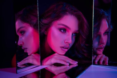 Canlı pembe ve mor neon ışıklarla aydınlatılmış, şık ve zarif modern bir ortamda güzellik, moda ve cazibe gösteren genç bir kadının yansımaları. Gece hayatı ve güzellik temaları için mükemmel..