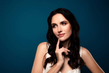 Çekici esmer kadın mavi gradyan arkaplanda zarafet ve güzelliği vurguluyor şık duruşunu, doğal güzelliğini ve büyüleyici görünümünü sergiliyor..