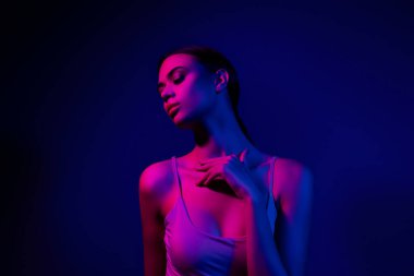 Genç bir kadın neon mavi ve pembe ışık altında poz verdi modern güzellik ve görkemli zarafet, moda, gece hayatı ve sanatsal kavramlar için ideal.