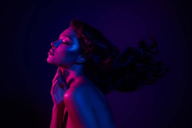 Canlı neon ışıklarla aydınlatılmış genç bir kadın, zarafet ve cazibe yayıyor, güzellik, kulüp hayatı veya moda temaları için mükemmel..