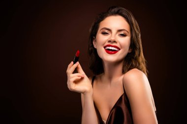 Kırmızı ruj sürmüş çekici esmer manken ve büyüleyici bir kıyafet, koyu bir arka plana karşı özgüven, tarz ve güzellik sergiliyor..