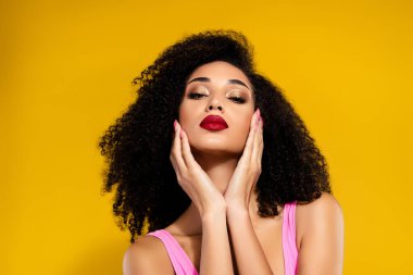 Kendine güvenen, şık giyinmiş zarif ve çekici bir kadın. Parlak sarı arka plan, yaz mevsimini güzelleştirir. Modern stilin, güzelliğin ve özgüvenin mükemmel tasviri.