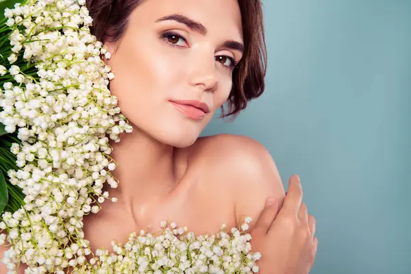 Çiçekli bir kadının profesyonel fotoğrafı. Doğal parfümün tadını çıkar. Cyan renk arka planında izole edilmiş boş bir alan..