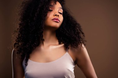 Şık, kıvırcık saçlı, güzelliği, zarafeti ve lüks tarzı vurgulayan genç bir kadının zarif tasviri..