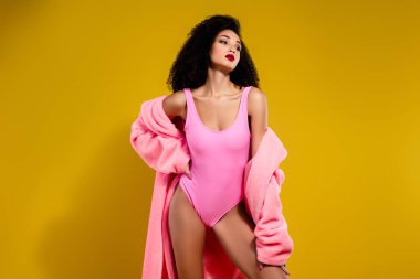 Renkli ve modaya uygun bir mayo giymiş güzel bir kadın, şık ve sofistike bir havayı çağrıştırıyor canlı renklerle ve zarif bir arka planla.