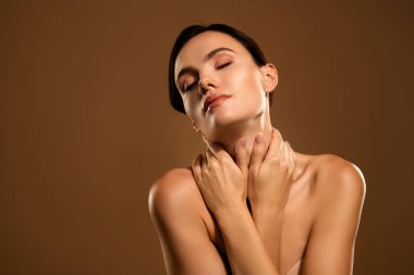 Pürüzsüz bir cilt ve kapalı gözler, bej arkaplanda parlak cilt ve güzellik kavramları olan genç bir kadının portresi.