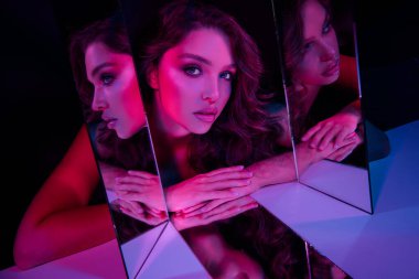 Neon pembe ve mavi ışıkla aydınlatılmış, çağdaş ve sanatsal bir estetik yaratan, zarif, genç bir esmer kadının görsel olarak çarpıcı bir görüntüsü..