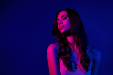 Canlı mavi ve pembe neon ışıklarla aydınlatılmış göz alıcı ve çekici bir kadın modeli, modern ve büyüleyici bir estetik yaratıyor, gece hayatı, moda ve güzellik kavramları için mükemmel..