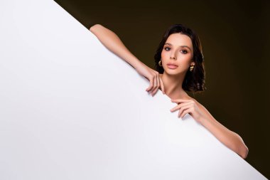 Zarif bir elbisenin içinde zarif ve alımlı bir arkaplana karşı duran çekici bir genç kadının portresi..