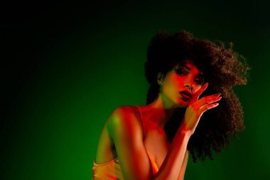 Şık ve şık bayan modeller, yeşil bir arka plana karşı canlı ışıklandırma, zarif ve sofistike pozlar verirler..