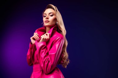 Göz kamaştırıcı genç bir kadın, kendine güvenen pembe bir ceketle, göz kamaştırıcı bir renk ve tarz gösterisinde güzelliği, modayı ve zarafeti vurguluyor..