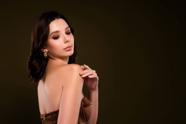 Zarif esmer kadın şık giyiniyor. Tarafsız bir arka plana karşı zarif ve zarif bir şekilde poz veriyor. Güzelliği, çekiciliği ve entelektüeli yakalıyor..