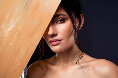 Çarpıcı özellikleri olan bir kadının sanatsal ve anımsatıcı bir portresi. Dikkatli ışıklandırma, gölgeler ve yaratıcı bir kompozisyon ile güçlendirilmiş gizemli bir cazibeyle vurgulanmış..