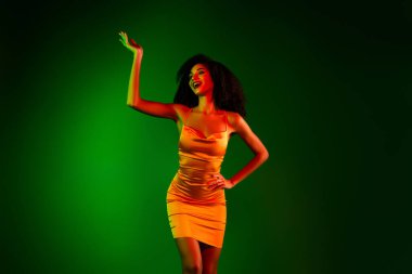 Zarif bir kokteyl elbisesi içinde yeşil gradyan arkaplan, etkileyici cazibe ve entelektüelliğe karşı kendine güvenen güzel ve tarz sergileyen muhteşem bir kadın model..