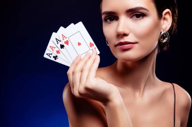 Çekici, zengin bir bayanın fotoğrafı. Elinde kartları var. Poker oynuyorlar..