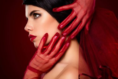 Kırmızı eldiven giymiş zarif bir kadın cazibe ve incelik sergiliyor. Büyüleyici güzellik ve çarpıcı makyaj canlı bir gradyan arka planına karşı şık cazibeyi vurguluyor..