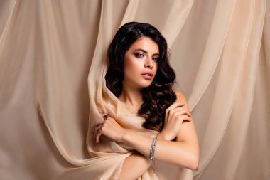 Esmer, şık bir kadın, bej renkli ve lüks bir çevresi var. Cazibesi ve zarafeti var. Yaratıcı tasarım ve editör projeleri için güzelliğin, cazibenin ve kadınlığın mükemmel tasviri.