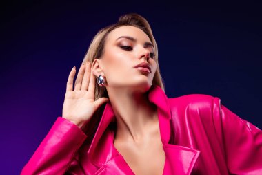 Göz kamaştırıcı bir kadın model, zarif ve güzel bir pembe yağmurlukla poz veriyor. Şık bir mor arkaplan karşısında yakalanan bu resim modern lüks moda ifadesi ve kendine güveni yansıtıyor.