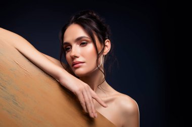 Entellektüel güzellik ve zarafet sergileyen genç esmer bir kadının büyüleyici tasviri, doğal makyaj ve sanatsal ışıklandırma ile lüks ve şık bir dokunuş için vurgulanmış..