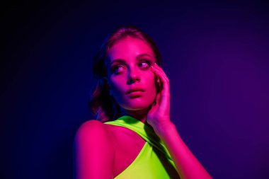 Yumuşak neon ışıklarla aydınlatılmış, modern kulüp benzeri bir ortamda güzellik, moda ve sanatın vurgulandığı şık bir genç kadının portresi..