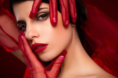 Kırmızı makyajlı ve eldivenli büyüleyici bir kadının yakın çekimi kadınlığı, zarafeti ve çekiciliği vurguluyor. Canlı tonlar ve şık kompozisyon..