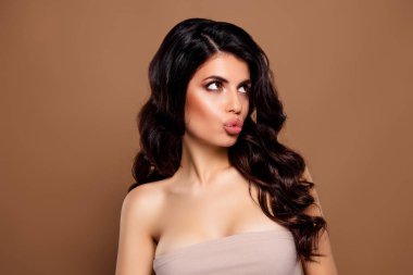 Şık bir esmer kadın lüks bir makyajla poz veriyor ve bej bir arka planda stil sahibi saçları var, göz kamaştırıcı ve güzel..