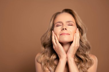 Zarif ve kendine güveni tam bir olgun kadın. Gözleri kapalı ve canlı bir gülüşü, ışıl ışıl bir güzelliği ve karizması var..