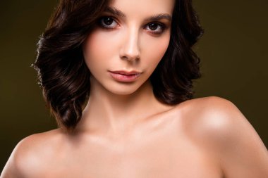 Çekici bir esmer, kendine güvenerek poz veriyor. Yumuşak ışıklandırma özelliklerini geliştiriyor. Güzellik, moda ve tarz kavramları için ideal zarif ve şık tasvirler.