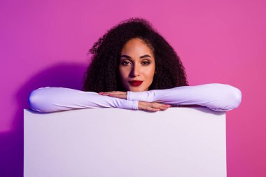 Zarif genç bir kadının portresi canlı mor renkli bir arka plana karşı modern tarzı ve kendine güvenen güzelliği sergiliyor. Neon ışıkları onun moda, çekici ve modaya uygun görünümünü vurguluyor..