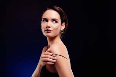 Çekici bir genç kadının portresi. Omuz kemerini çıkar. Siyah arka planda izole edilmiş bir elbise giy..