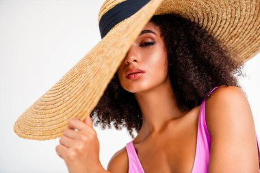 Geniş bir şapka takan, şık bir genç kızın parlak stüdyo görüntüsü. Şık, modern bir tarzda zarafet ve yaz titreşimleri yayıyor..